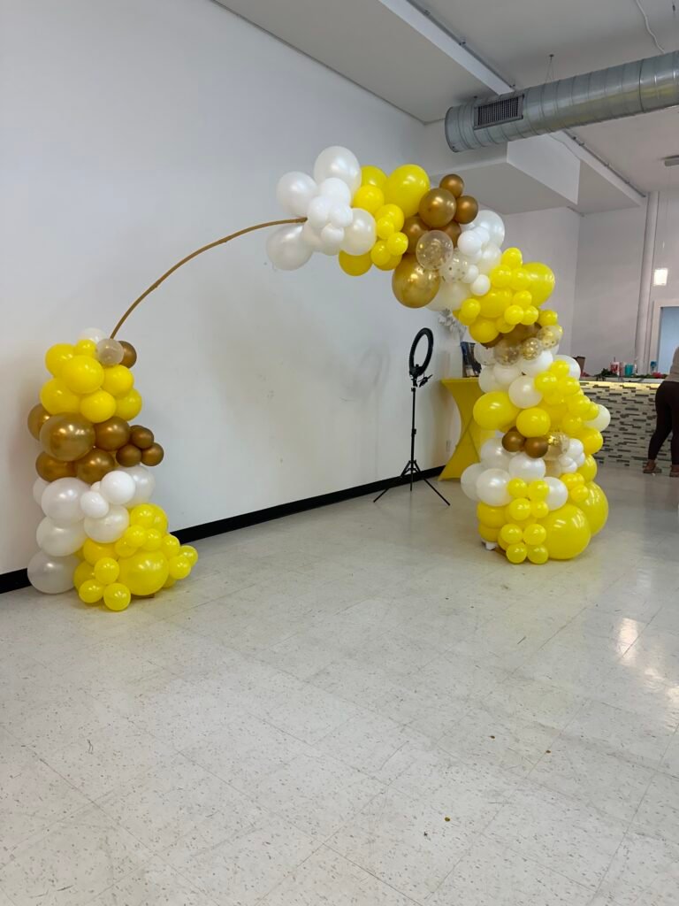 DIY balloon arch in gold and white for party setup at home