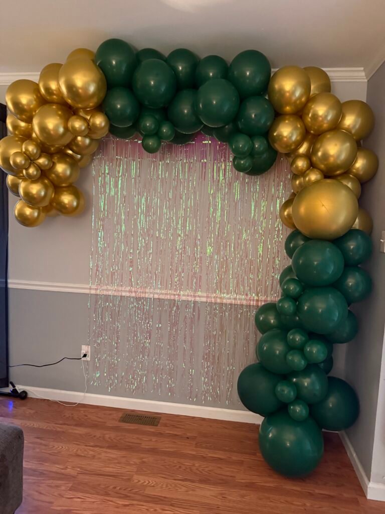 Balloon backdrop with green and gold setup for party