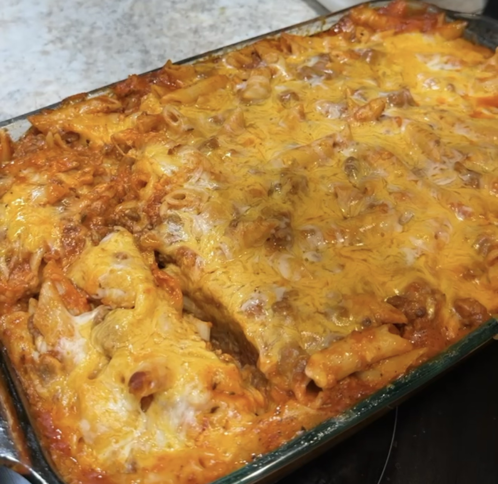 Easy mostaccioli recipe for a large family baked with ground beef, pasta sauce, and melted cheese